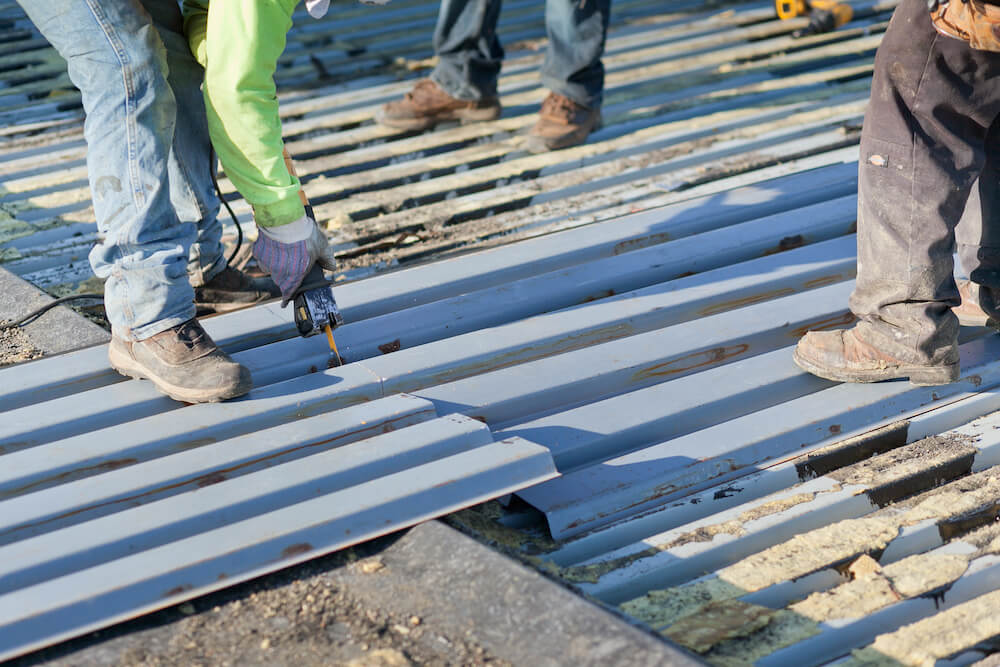 worker installing sheet metal on a roof