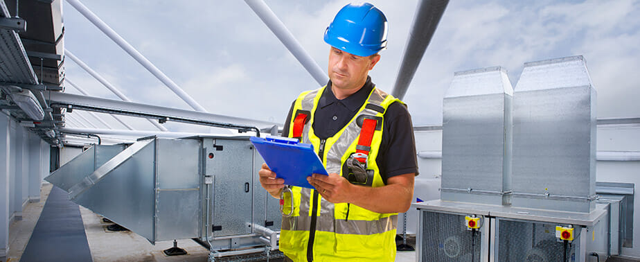 contractor on roof analyzing clipboard with information on it