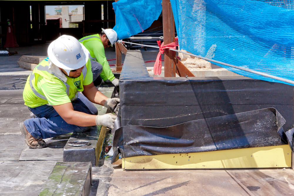 two Maxwell workers in process of working on roof installation