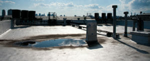 flat commercial roof with rain puddles collected from a previous storm