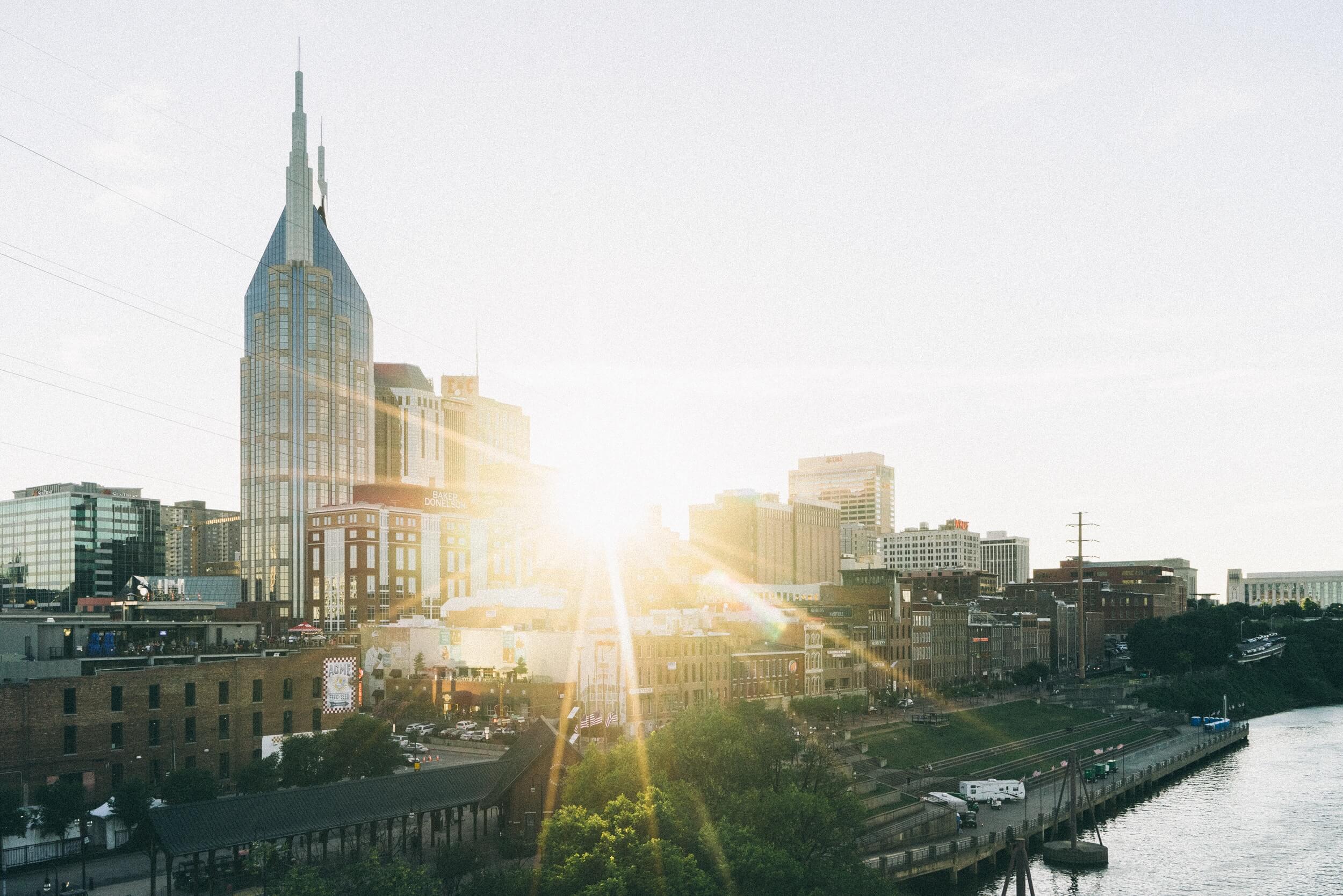 nashville skyline with sun beaming through the buildings and the at&t building stick out above all other buildings