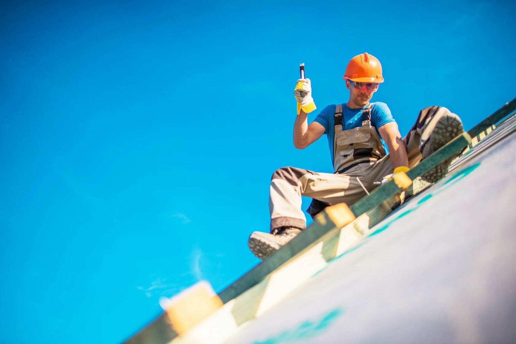 Worker on New Building Roof hammering