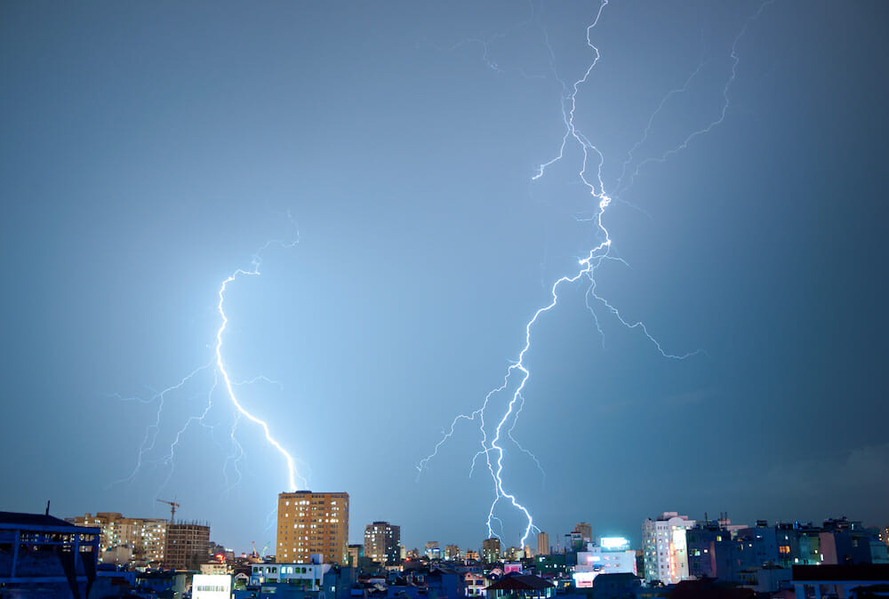 Two powerful lightnings hitting synchronously resembling a dangerous sinister dance in the night sky