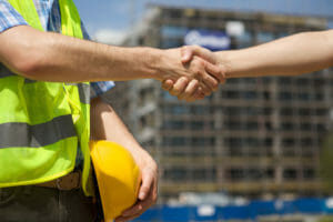 Architects shaking hand at construction site