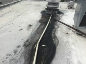 mopping debris from a commercial roof