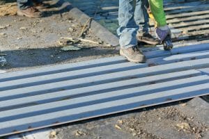 worker installing sheet metal on a roof