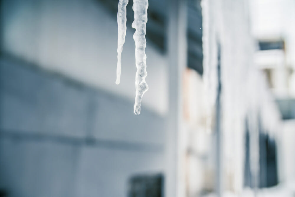 close up of icicles hanging off of roof