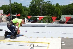 Maxwell roofer using screw driver during roof repair
