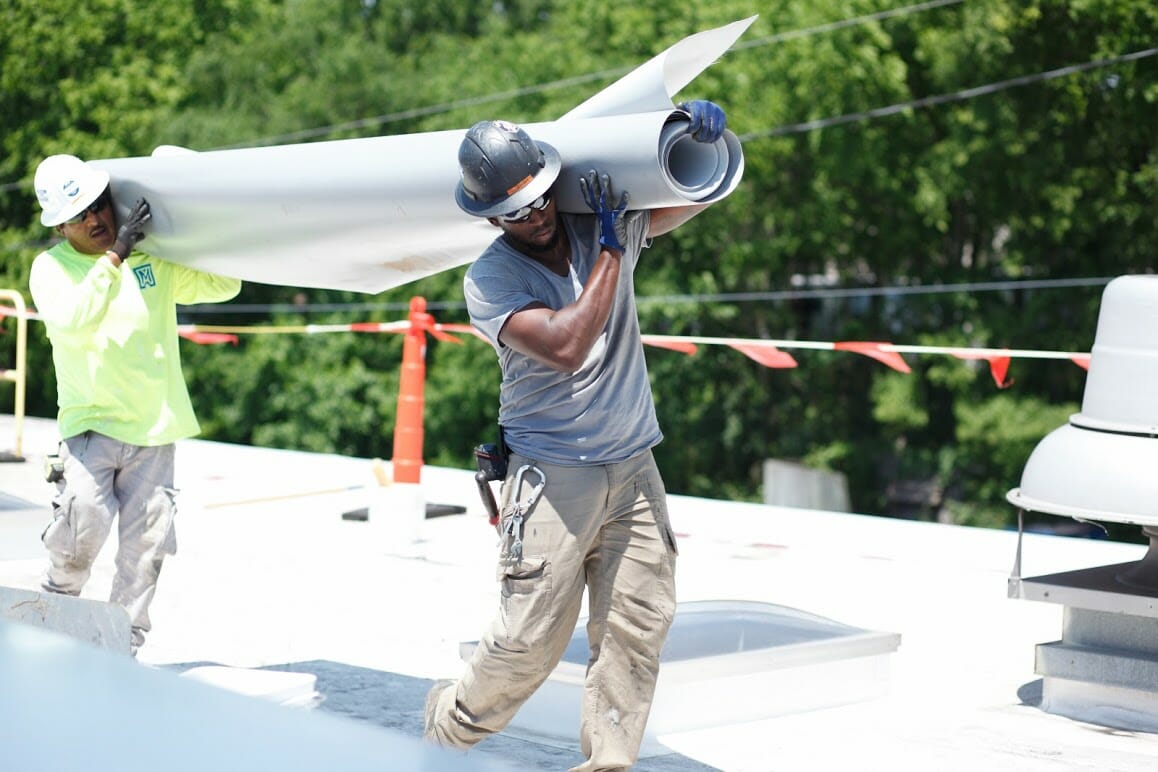 Maxwell Roofing team members moving roofing materials