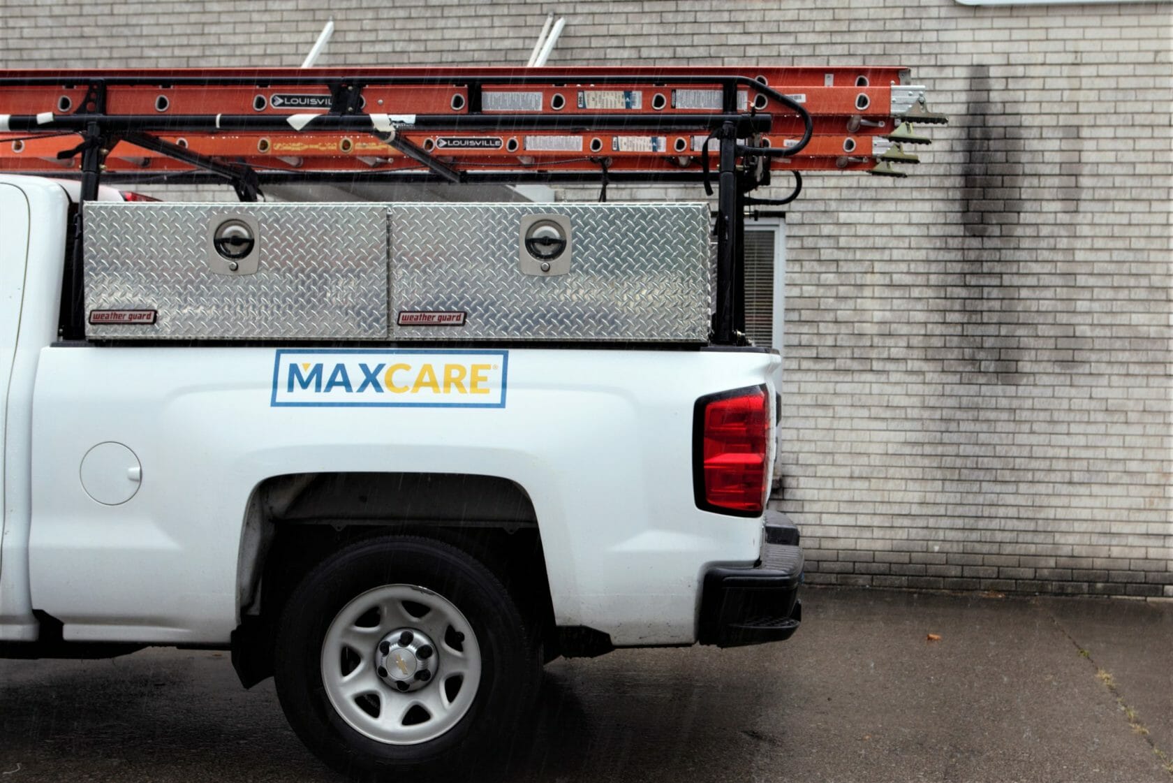 side profile of a white Maxwell Roofing maintenance truck