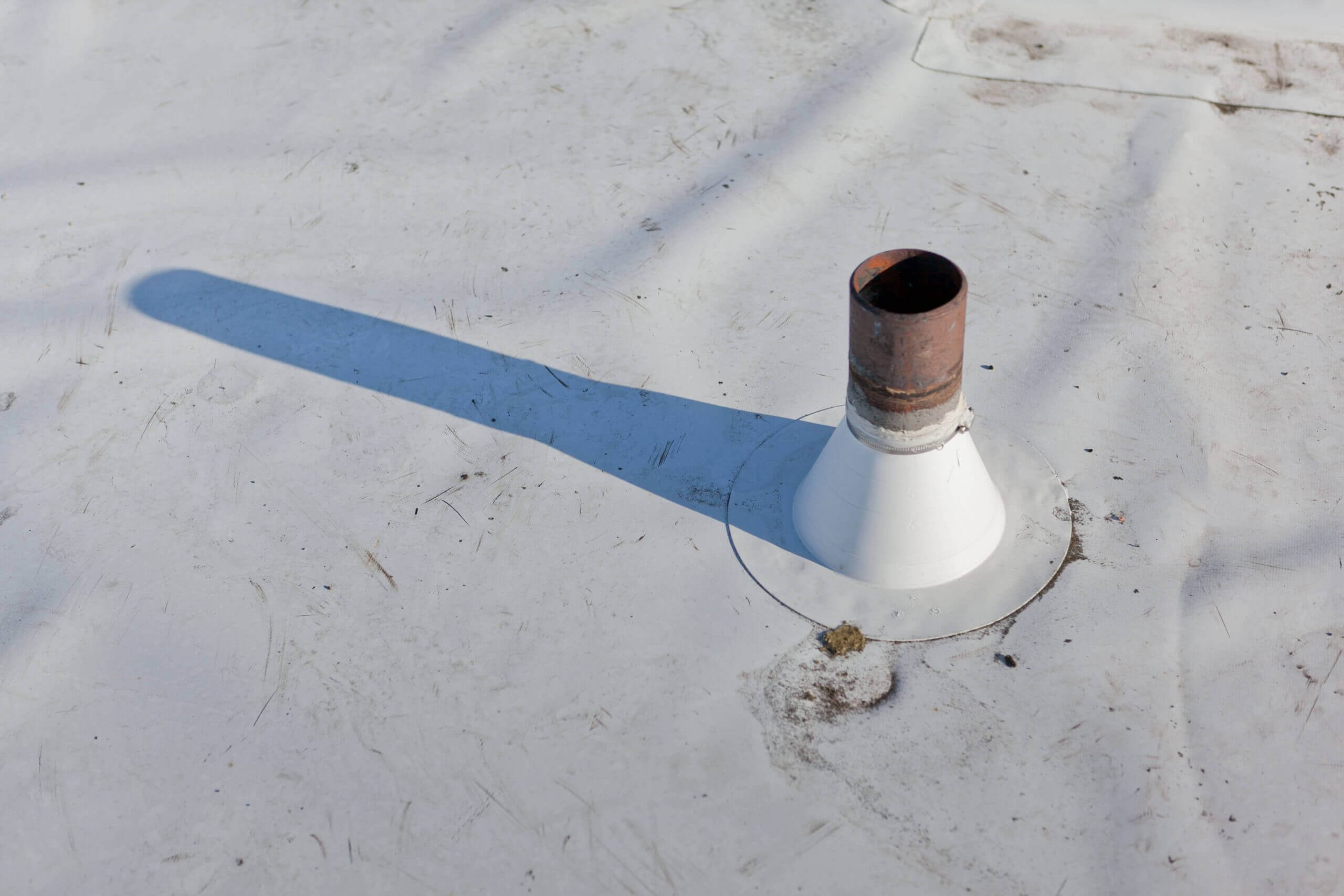 commercial roof with a drain sticking out towards the sky leaving it vulnerable to roof penetration