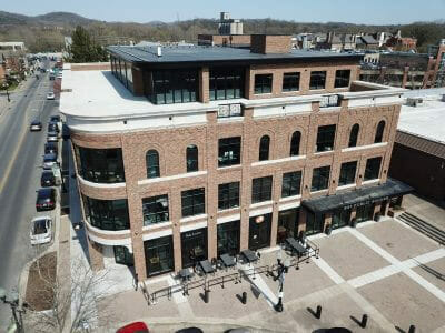 ariel view of tan commercial building with people walking on street below