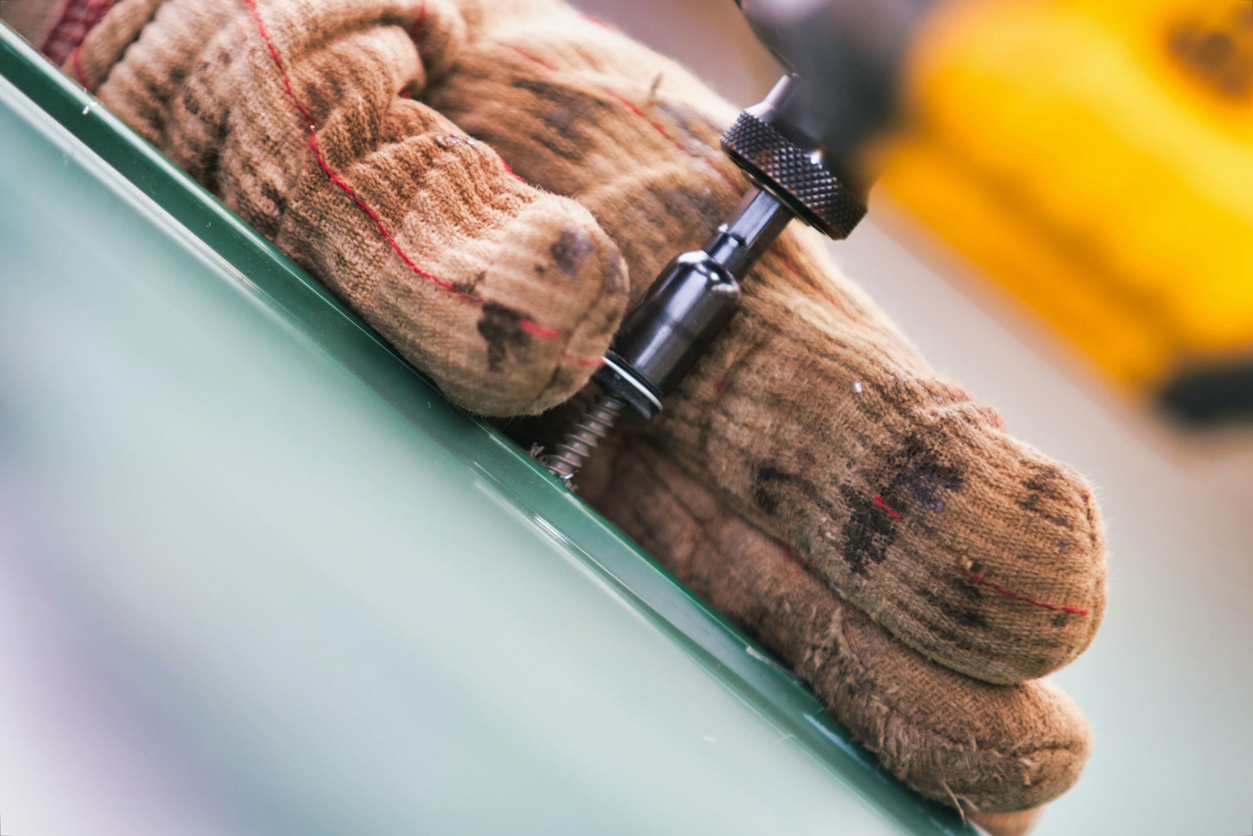 close up of hand drilling into metal.