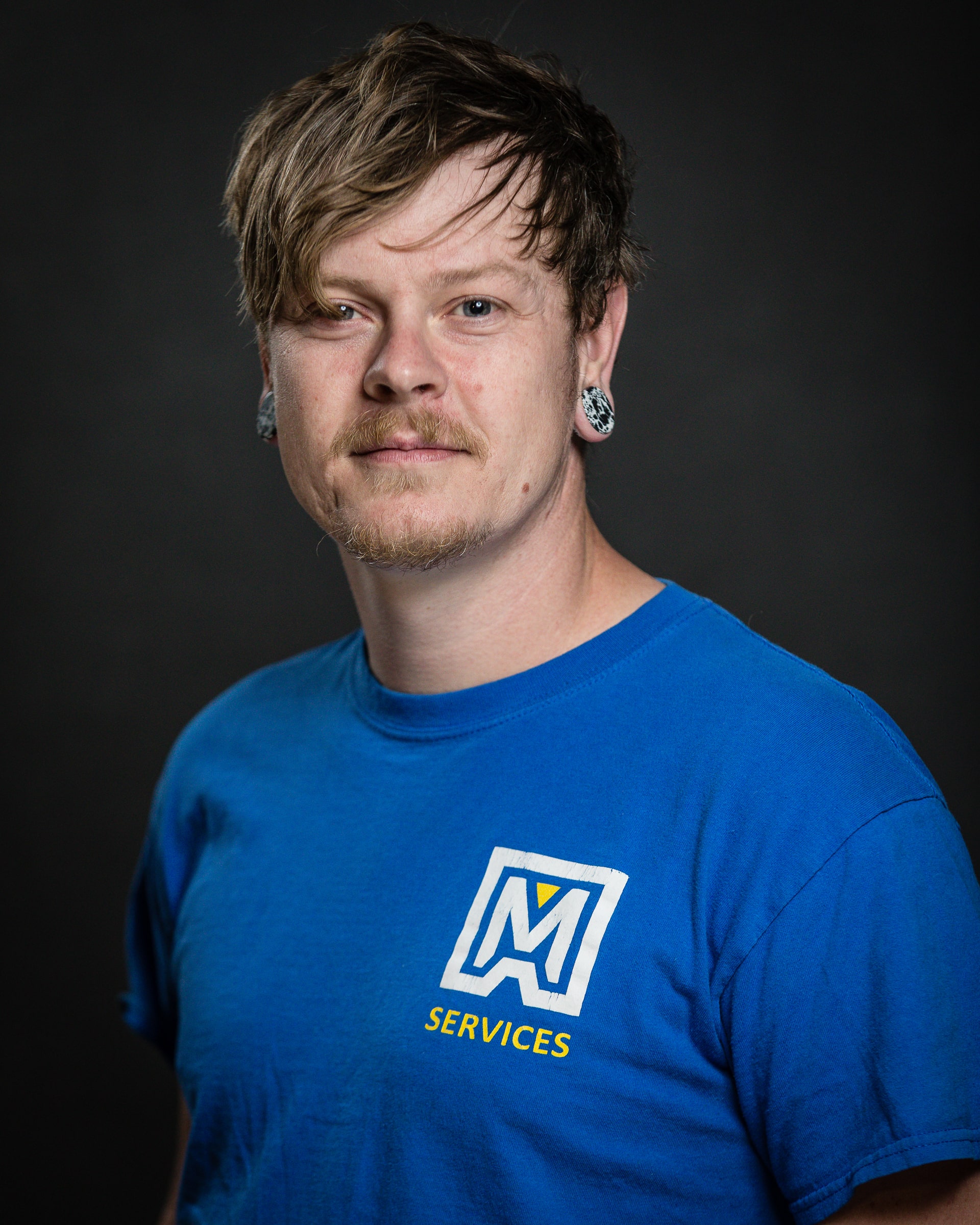 portrait of lee cox in a maxwell roofing blue t-shirt.